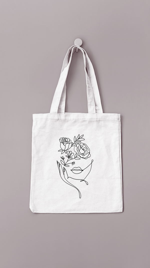 Sac réutilisable de couleur crème avec un visage fleuri floqué en noir