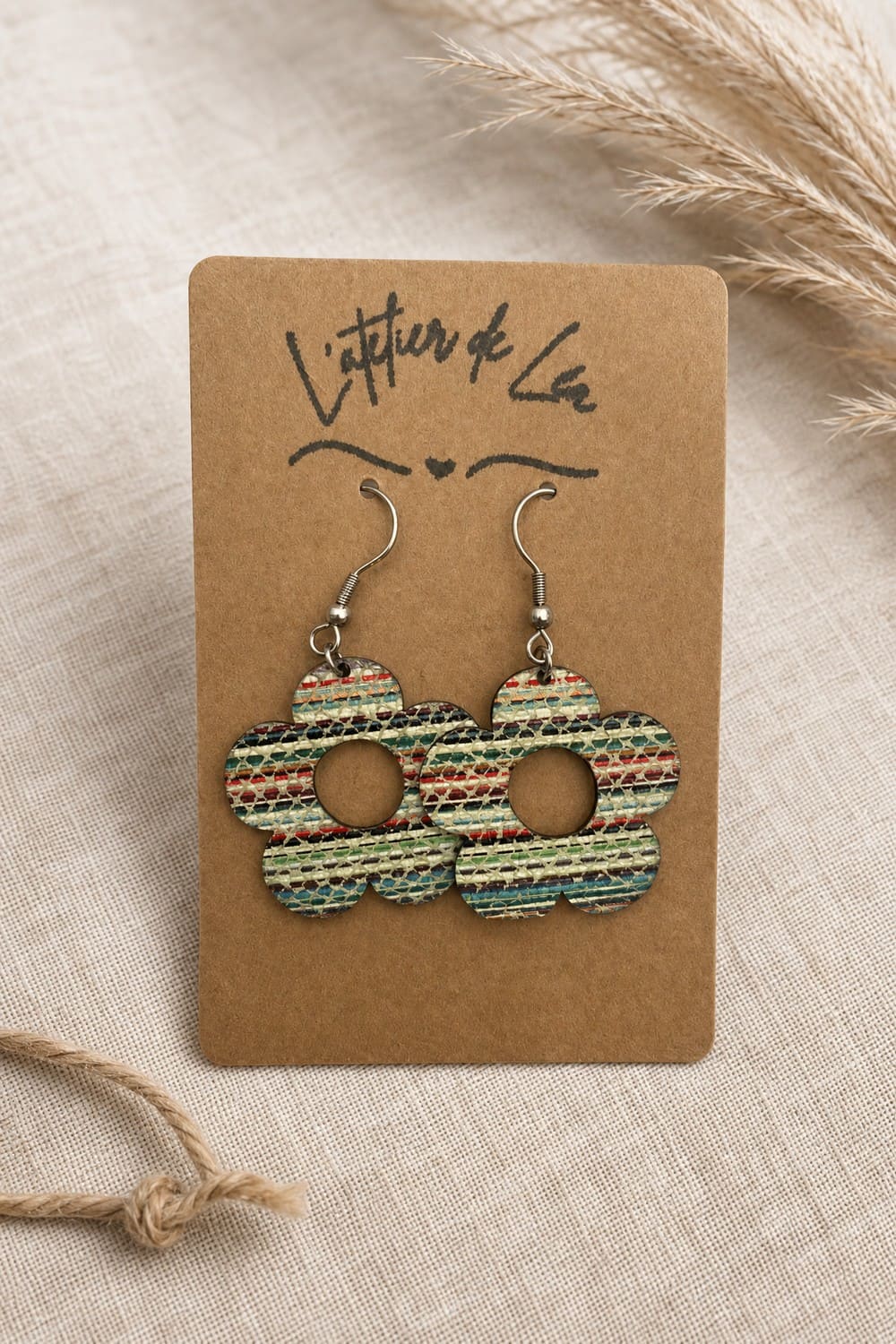 Boucles d'oreilles en cuir montées sur un bijou en acier inoxydable en forme de fleurs rayées